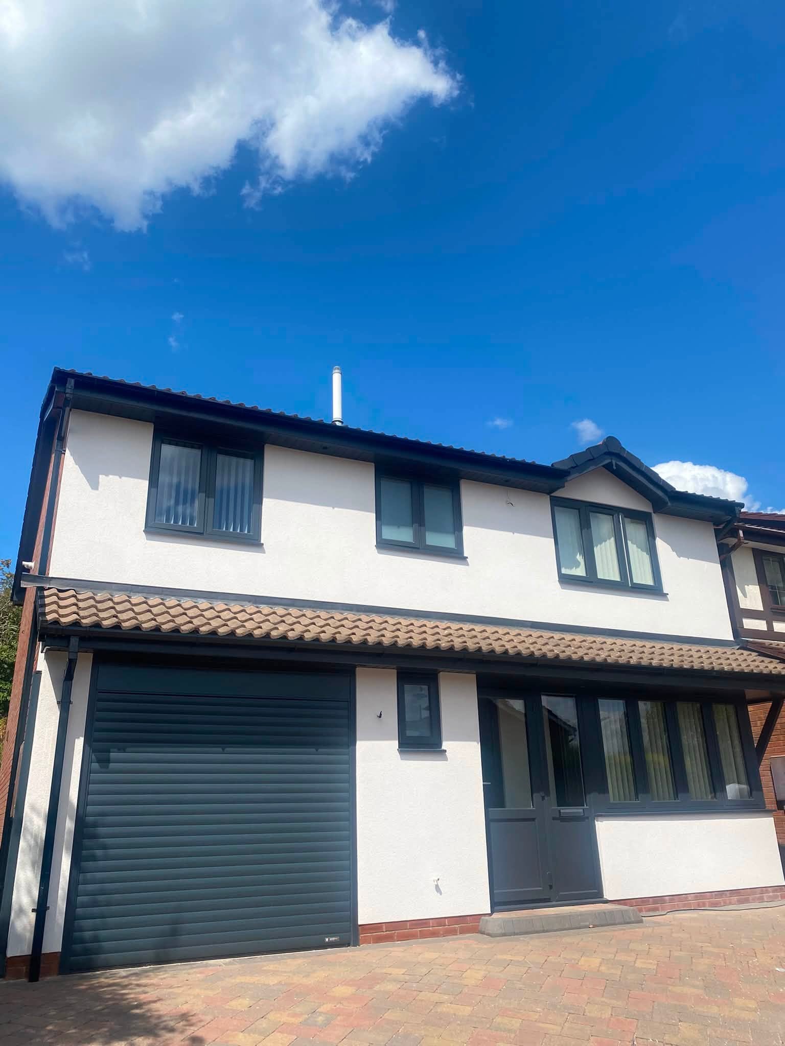 Full house exterior with anthracite grey fascia, soffit and guttering installed — West Midlands roofline specialists